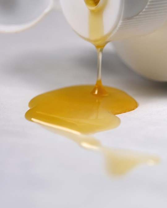 A close up of Lovebee's natural baby soap with honey pouring from the container